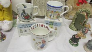 Two boxed Wedgwood Peter Rabbit mugs and one other.