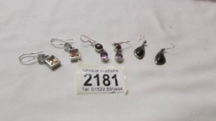 Three pairs of silver pendant earrings.