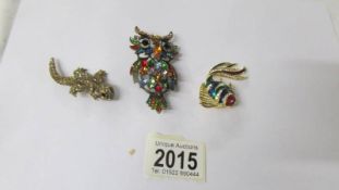 Three sparkly brooches being an owl, a fish and a lizard.