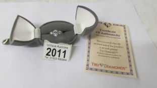 A 9ct gold ring set three simulated "Tru Diamonds" with certificate, size T.