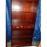 A mahogany effect book case with 2 drawers.