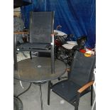 A circular garden table and 2 metal and mesh framed garden chair with teak arms.