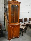 A mahogany effect corner cabinet.