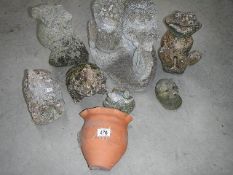 A collection of concrete animal garden ornaments and a terracotta wall planter.