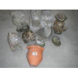 A collection of concrete animal garden ornaments and a terracotta wall planter.