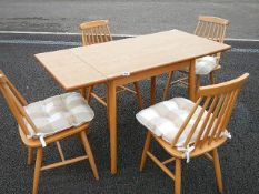 A solid pine extending dining table and 4 Ercol style chairs.