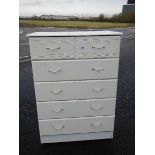A 2 over 4 white chest of drawers.