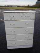 A 2 over 4 white chest of drawers.