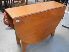 A teak drop leaf dining table.