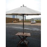 A mahogany garden table with parasol.