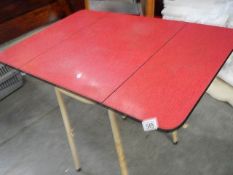 A 1950's formica drop leaf table on tubular steel frame.