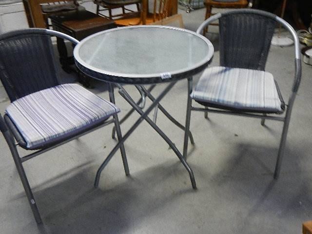 A glass top garden table and 2 chairs,.