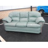 A green leather sofa in good condition.