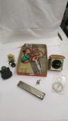 A mixed lot of collectable items including harmonica, travel clock etc.