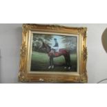 A gilt framed print of a racehorse.