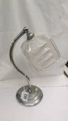 An art deco chrome table lamp with glass shade.