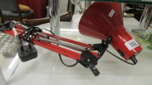 A red anglepoise lamp (missing base).