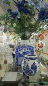 A blue and white ginger jar and a blue and white pot with blue flowers.