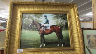 A gilt framed print of a racehorse.