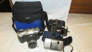 An HP Photosmart camera, a Canon Camera, A Minolta camera and a Kodak camera case.