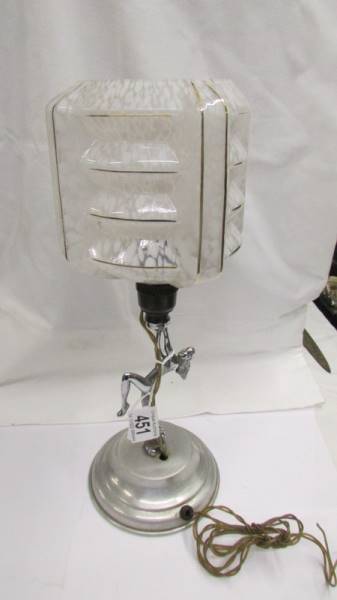 An art deco chrome nude figure table lamp with glass shade.