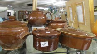 Three brown pottery lidded pots, 2 other pots and a teapot.