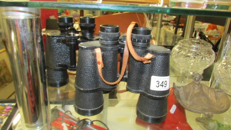 A cased pair of binoculars and an uncased binoculars.