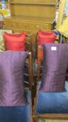 Two purple and two red silk cushions.