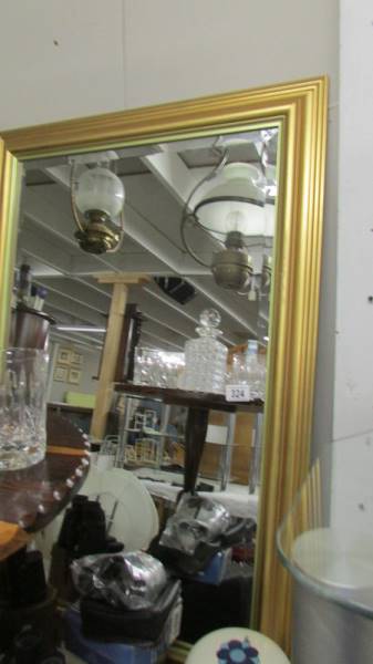 A gilt framed bevel edged mirror.