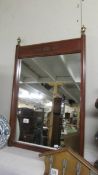 A mahogany framed mirror with brass inlay to top.