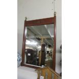 A mahogany framed mirror with brass inlay to top.