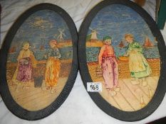 A pair of Bretby Dutch scene wall plaques.