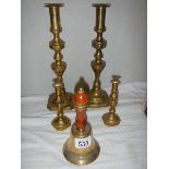 Two pairs of brass candlesticks and a brass bell.