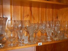 A shelf of assorted drinking glasses.