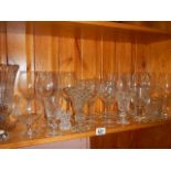 A shelf of assorted drinking glasses.