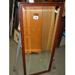 A framed and glazed bevel edged mirror.