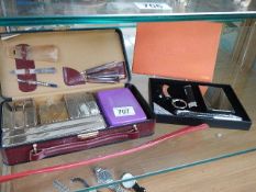 A cased vanity set and one other item.