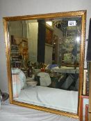 A gilt framed bevel edged mirror.