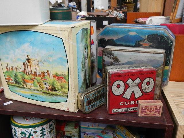 Four shelves of assorted collector's tins.