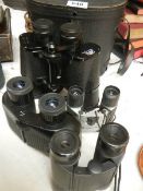 A cased pair of binoculars and three others.