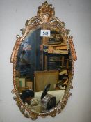 A gilt framed oval bevel edged mirror.