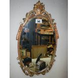 A gilt framed oval bevel edged mirror.