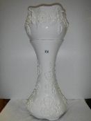 A white jardiniere on stand.