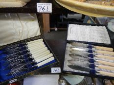 A cased set of fish knives and forks together with a cased set of fish knives.