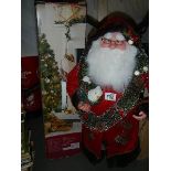 A Santa Clause figure and a boxed Christmas tree,.