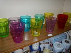A quantity of coloured glass tumblers.