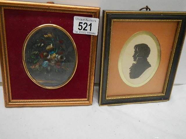 A framed and glazed silhouette and a floral painting.