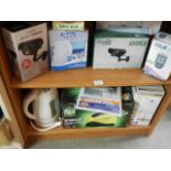 Two shelves of assorted household items including CCTV camera's.
