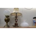 A brass oil lamp, a table lamp and an oil lamp shade.