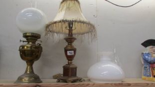 A brass oil lamp, a table lamp and an oil lamp shade.